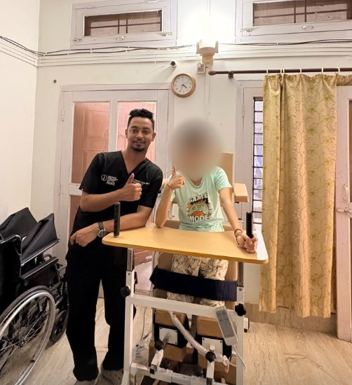 Standing practice with a patient using a standing frame