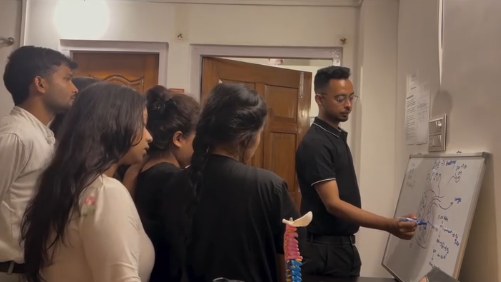 Teaching a group of physiotherapy students at a whiteboard